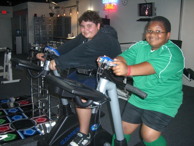Children exercising on youth-sized stationary bikes inside the original Superfit Kids facility